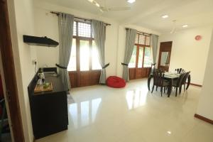 une cuisine et une salle à manger avec une table et des chaises dans l'établissement King's Court Kandy, à Kandy