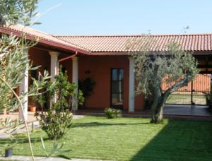 una casa con un patio verde con una casa en CuccuruAio' B&B, en Siamaggiore