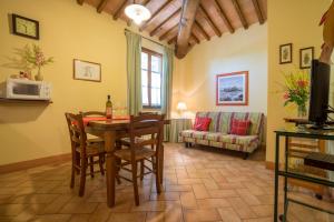 sala de estar con mesa, sillas y sofá en Agriturismo Il Poggetto, en San Gimignano