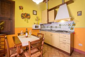 a kitchen with a table and a dining room at Agriturismo Il Poggetto in San Gimignano