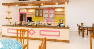a restaurant with a counter with tables and chairs at Hotel Madiyara in Mukomuko