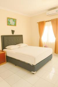a bedroom with a bed in a room at Hotel Madiyara in Mukomuko