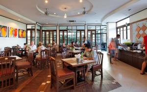 a dining room with people sitting at tables in a restaurant at Pattaya Loft in Pattaya Central