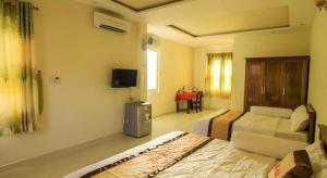 una camera d'albergo con due letti e una televisione di Lam Ha Resort a Phu Quoc