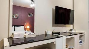 a room with a desk with a computer and a tv at BENIKEA Technovalley Hotel in Daejeon