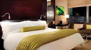 a bedroom with a large bed with a green blanket at Luxury Suites International by Vdara in Las Vegas