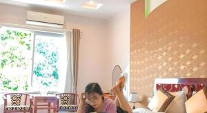 a girl sitting on a bed holding a wii remote at Ngoc Bach Hotel in Mai Chau +73 photos