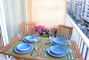 una mesa de madera con placas azules y gafas en el balcón en Malaga Center Flat Holidays Salitre, en Málaga