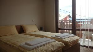 a bedroom with two beds and a balcony with a view at Andreevite Houses in Sapareva Banya