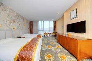 a hotel room with two beds and a flat screen tv at Junlai Hotel Pudong Airport Shanghai in Shanghai