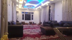 a living room with couches and a blue ceiling at Cloud Shades in Srinagar +1 photo
