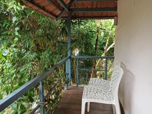 a white chair sitting on a porch at SAN Brick cottages in Kuilapayam