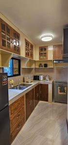 a large kitchen with wooden cabinets and stainless steel appliances at IBM Homestay in Butuan