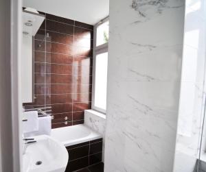 a bathroom with a sink and a toilet and a shower at Hotel Villa Laurel in Lovran +14 photos