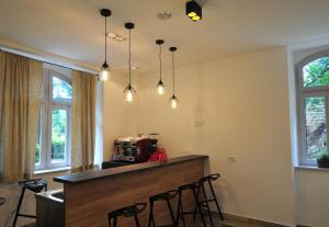 a kitchen with a bar with chairs and lights at Hotel Villa Laurel in Lovran