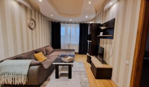 a living room with a couch and a tv at Erdvus 3 kambarių butas Ventos 22 in Mažeikiai