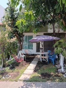 einen Tisch und Stühle sowie einen Regenschirm vor einem Haus in der Unterkunft Casa de descanso in Atlacholoaya