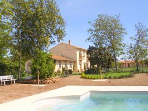 a house with a swimming pool in front of a yard at La Pulledraia Del Podere Montegrappa in Alberese