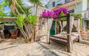 a bed in a stone wall with purple flowers at Cozy Home In Maslenica With Kitchen in Maslenica