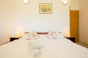 杜布羅夫尼克的住宿－Sunshine Apartments，卧室配有白色的床和2个枕头
