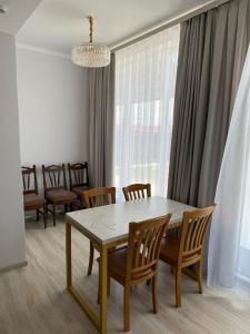 a dining room with a table and chairs at Kushchu Guest House in Bishkek +6 photos