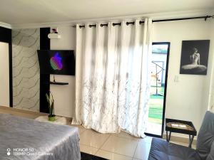 a bedroom with a bed and a large window at Palma Royal Ensuite in Pretoria