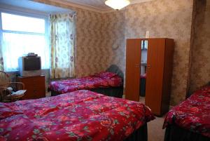 a hotel room with two beds and a tv at Brookfield Guesthouse in Cleethorpes