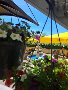 a view of a patio with flowers and umbrellas at Hotel Adler in Augsburg