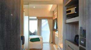 Habitación con dormitorio con cama y ventana en Phattrasom Villa, en Cha Am