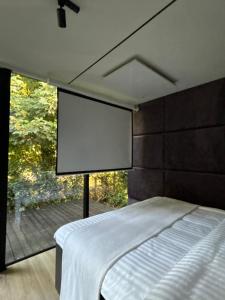 a bedroom with a bed and a large window with a screen at Spiegelhuisje aan zee in Burgh Haamstede