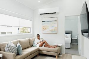 a woman sitting on a couch in a living room at Tasman Holiday Parks - North Star in Hastings Point