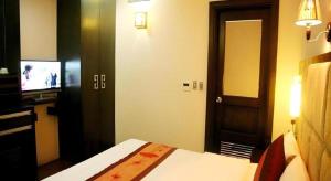 a hotel room with a bed and a television at New Moon Hotel in Hanoi