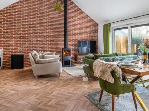 ein Wohnzimmer mit einer Ziegelwand in der Unterkunft Uk47692 - Wiggles Cottage in Wimbish
