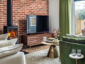 ein Wohnzimmer mit Kamin und Fernseher in der Unterkunft Uk47692 - Wiggles Cottage in Wimbish