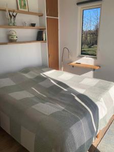 a bedroom with a bed with a checkered blanket at Holiday Home By The Water In Rødvig, Stevns in Rødvig