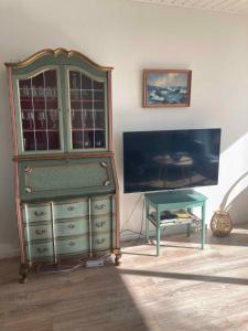 a green dresser and a table in a room at Holiday Home By The Water In Rødvig, Stevns in Rødvig