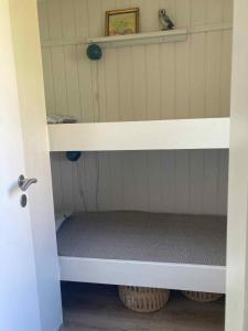 a bunk bed with a bench in a room at Holiday Home By The Water In Rødvig, Stevns in Rødvig +16 photos