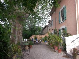 a courtyard with chairs and a tree next to a building at Berne &Michel in Montfavet