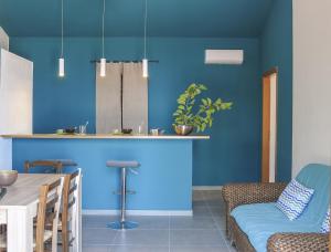 a kitchen with blue walls and a table and chairs at Villa Bruca 2 appartamenti al mare in Caronia Marina +22 photos