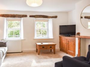 a living room with a tv and a couch at Riverside Cottage in Keswick
