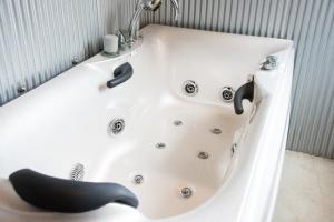 a white bath tub with a black whale sitting in it at Rockstar Villa 江井浜STYLE in Awaji