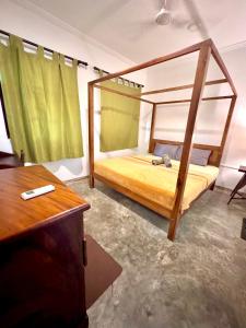 a bedroom with a bunk bed and a desk at Coastal Cloud Backpackers in Unawatuna