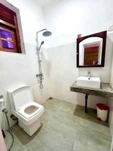 a bathroom with a toilet and a sink at Coastal Cloud Backpackers in Unawatuna