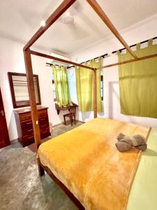 a bedroom with a large bed and a desk at Coastal Cloud Backpackers in Unawatuna