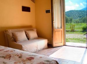 a bedroom with a bed and a sliding glass door at La Pulledraia Del Podere Montegrappa in Alberese