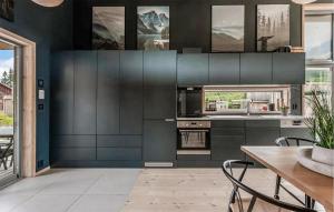 a kitchen with black cabinets and a table with chairs at Lovely Home In Ål With House Sea View in Ål