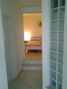 a hallway with a bedroom with a bed in a room at Apartments MiaMaja in Novalja