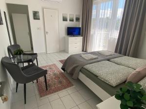 a bedroom with a bed and a table and a television at Lillybeth Lakeside in Keszthely