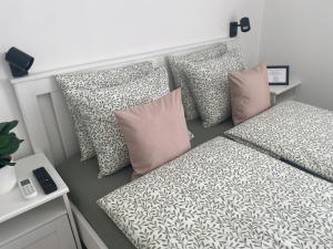a room with a bed with pillows at Lillybeth Lakeside in Keszthely