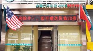 an entrance to a building with an american flag at GreenTree Inn Shanghai South Railway Station Xujiahui Stadium Subway Station Shell Hotel in Shanghai